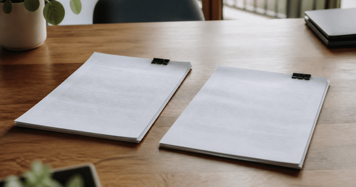 Deux contrats immobiliers poses cote a cote sur bureau