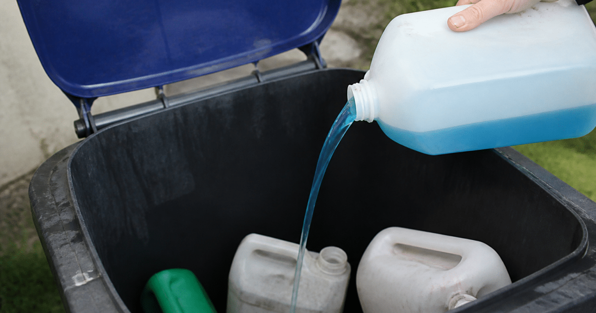 Bidon antigel bleu versé dans bac recyclage exterieur