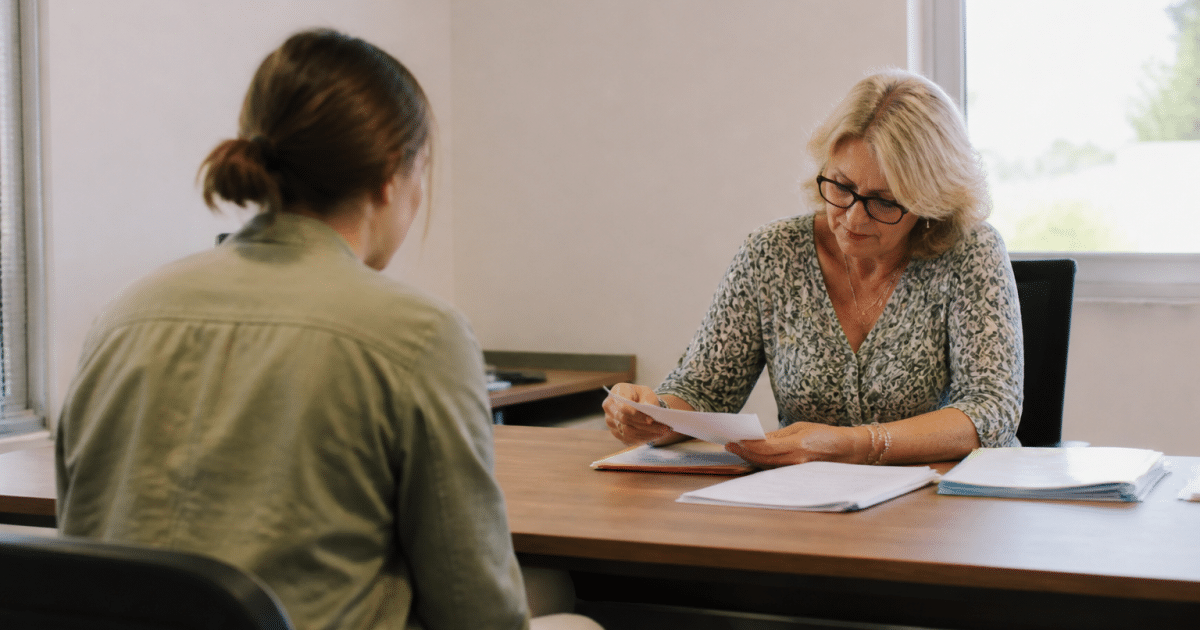 Personne assise face a une table administrative avec documents