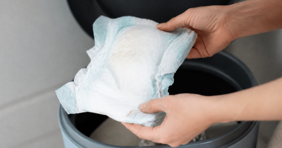 Mains tenant couche usagee au-dessus poubelle ouverte