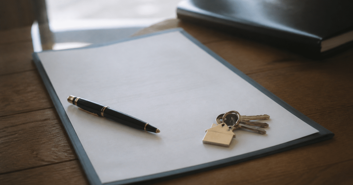 Document notarié posé sur table avec stylo et clés maison