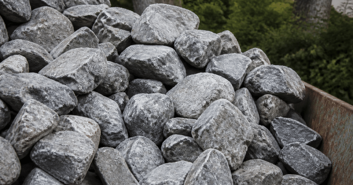Tas de pierres grises empilees dans benne metallique