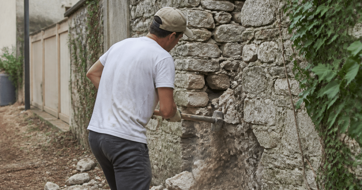 Deux maisons separees par mur pierre avec echafaudage construction d'un cote