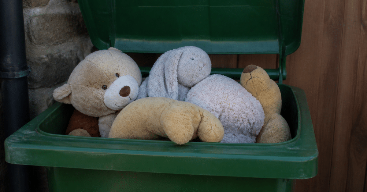 Peluches usees empilees dans bac recyclage ouvert