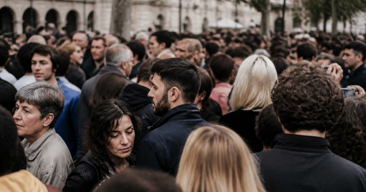 Foule dense de personnes debout dans rue urbaine