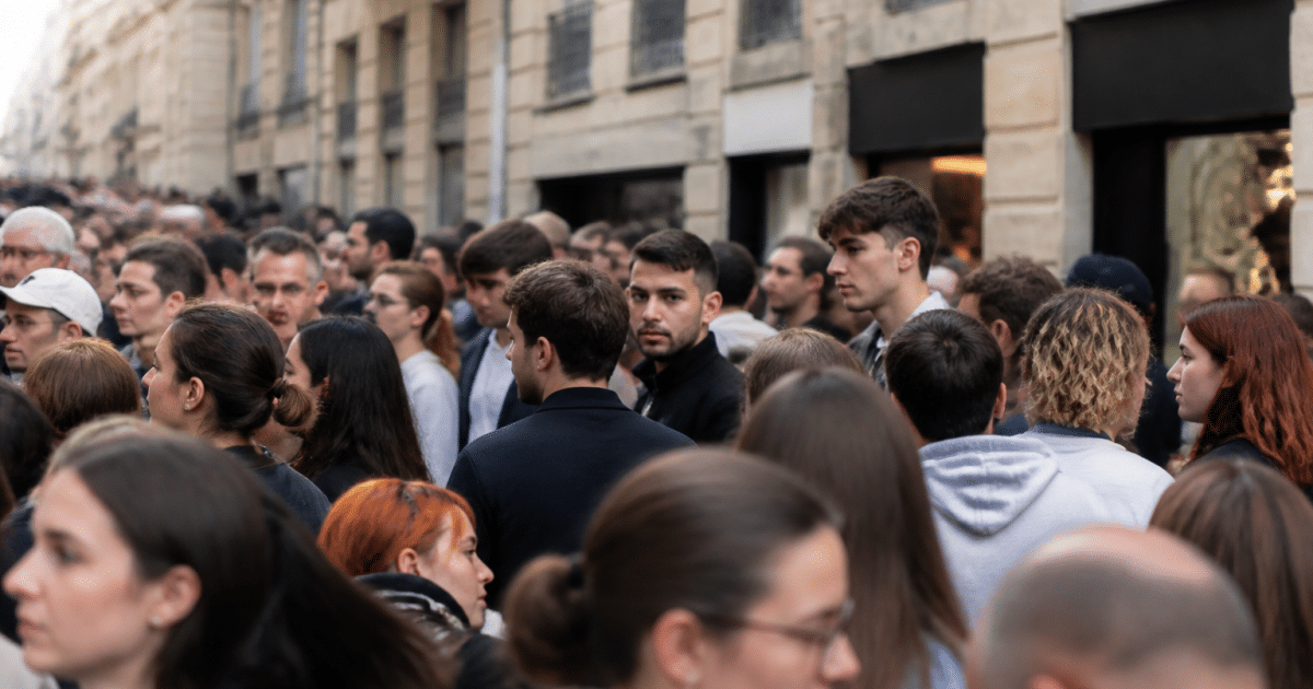 Foule dense de personnes debout dans rue urbaine montpelliéraine