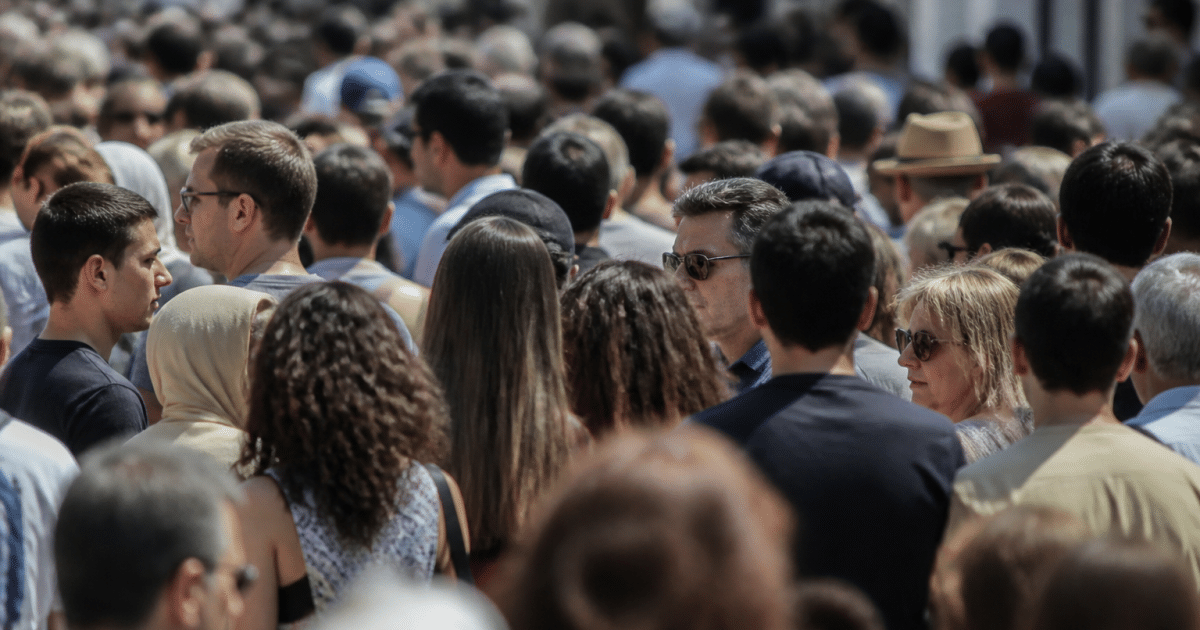 Foule dense de personnes debout côte à côte dans rue urbaine
