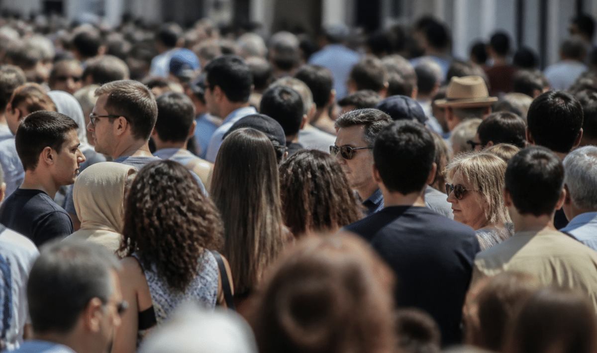 Foule dense de personnes debout côte à côte dans rue urbaine