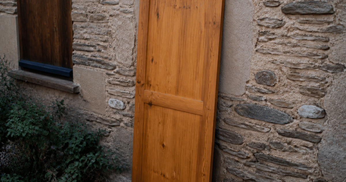 Porte en bois posee verticalement contre mur exterieur