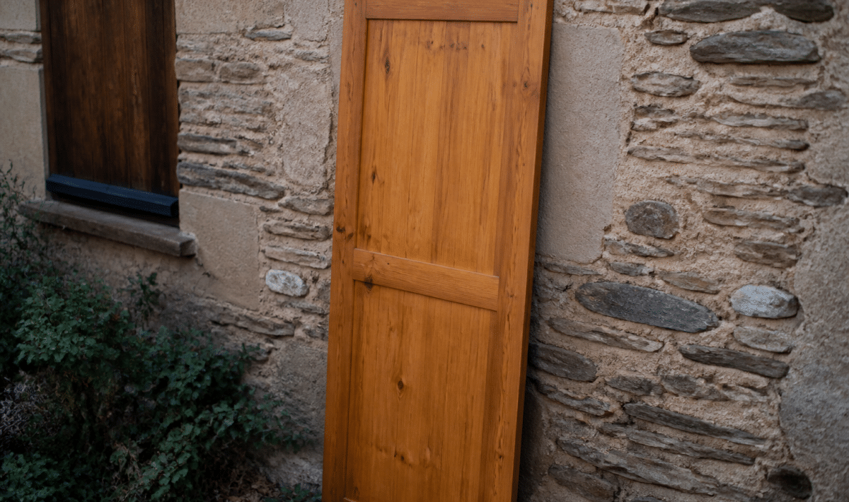 Porte en bois posee verticalement contre mur exterieur