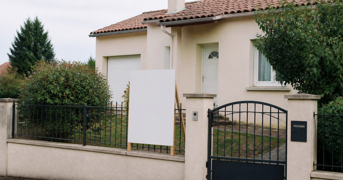 Maison avec panneau vente affichant prix immobilier devant
