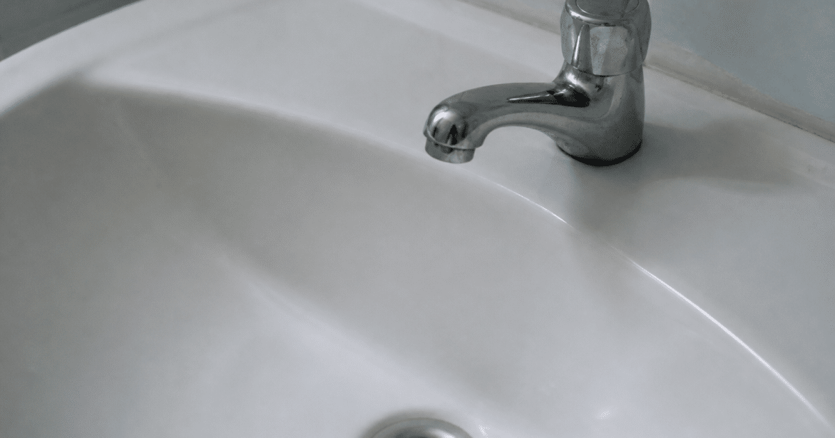 Robinet ferme d'eau stagnante dans evier blanc vide