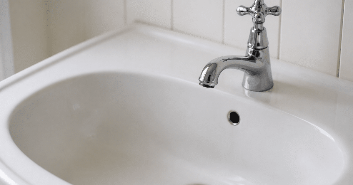 Robinet ferme d'eau stagnante dans evier vide blanc