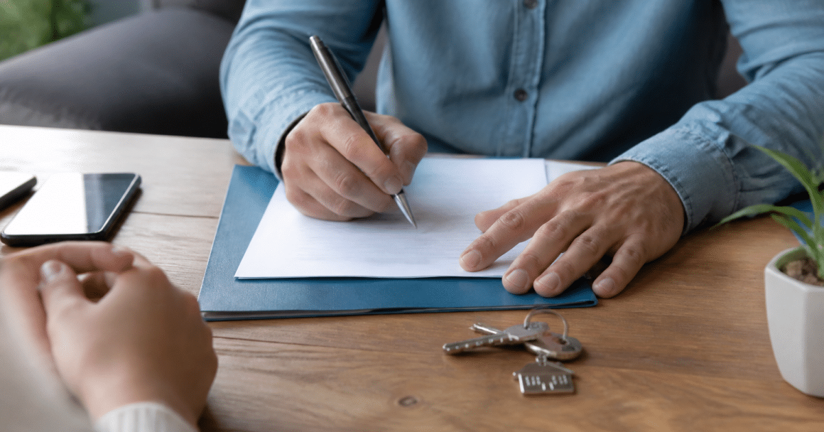 Document immobilier signé sur table avec stylo et clés